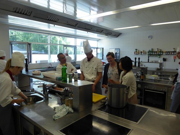 SchülerInnen beim Kochen in der Lehrküche